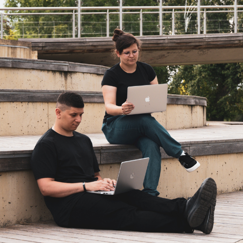 Gabrysia i Mikołaj pracują z laptopami w plenerze